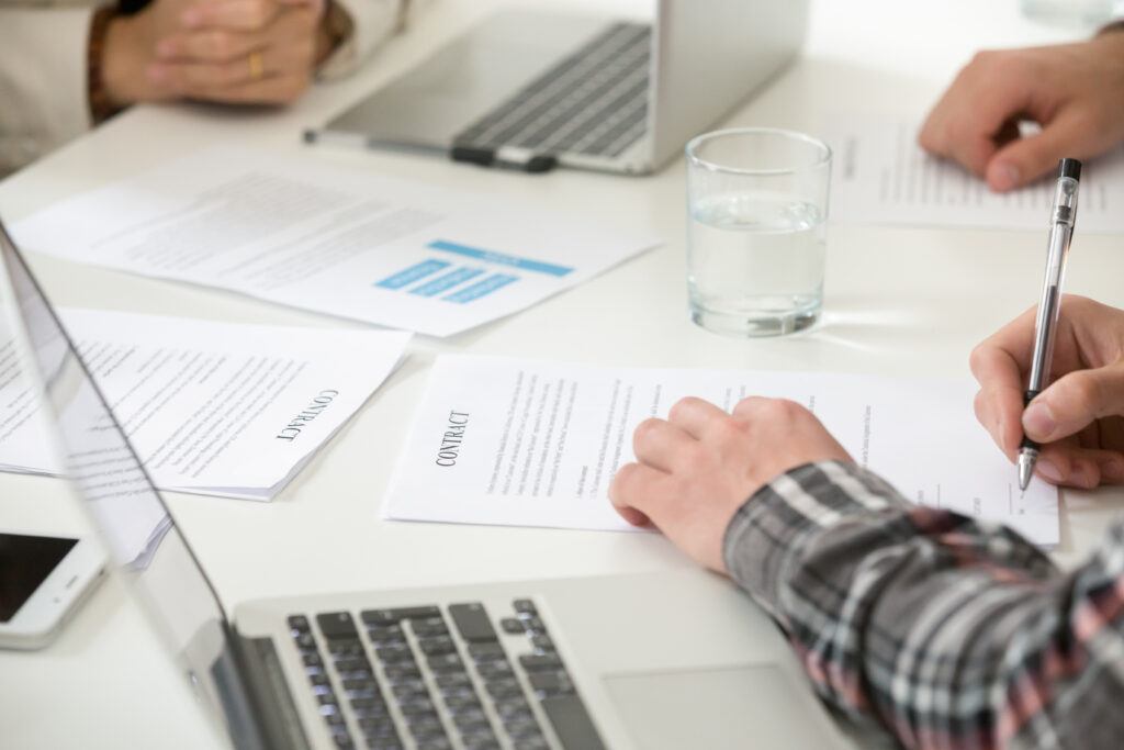 Businessman signing business contract filling document form at m