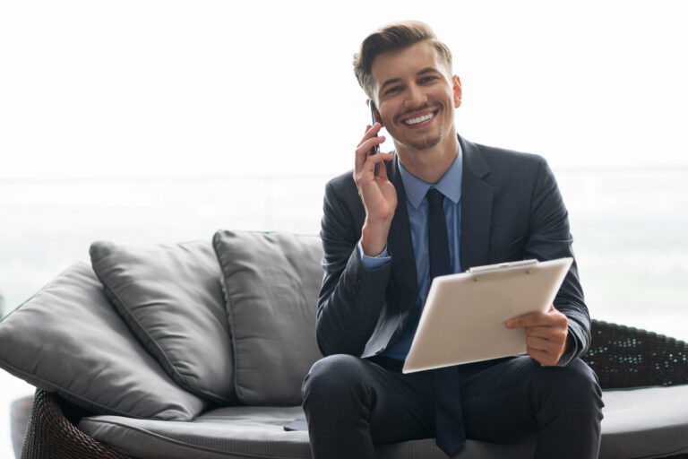 Smiling Businessman Calling on Phone on Sofa